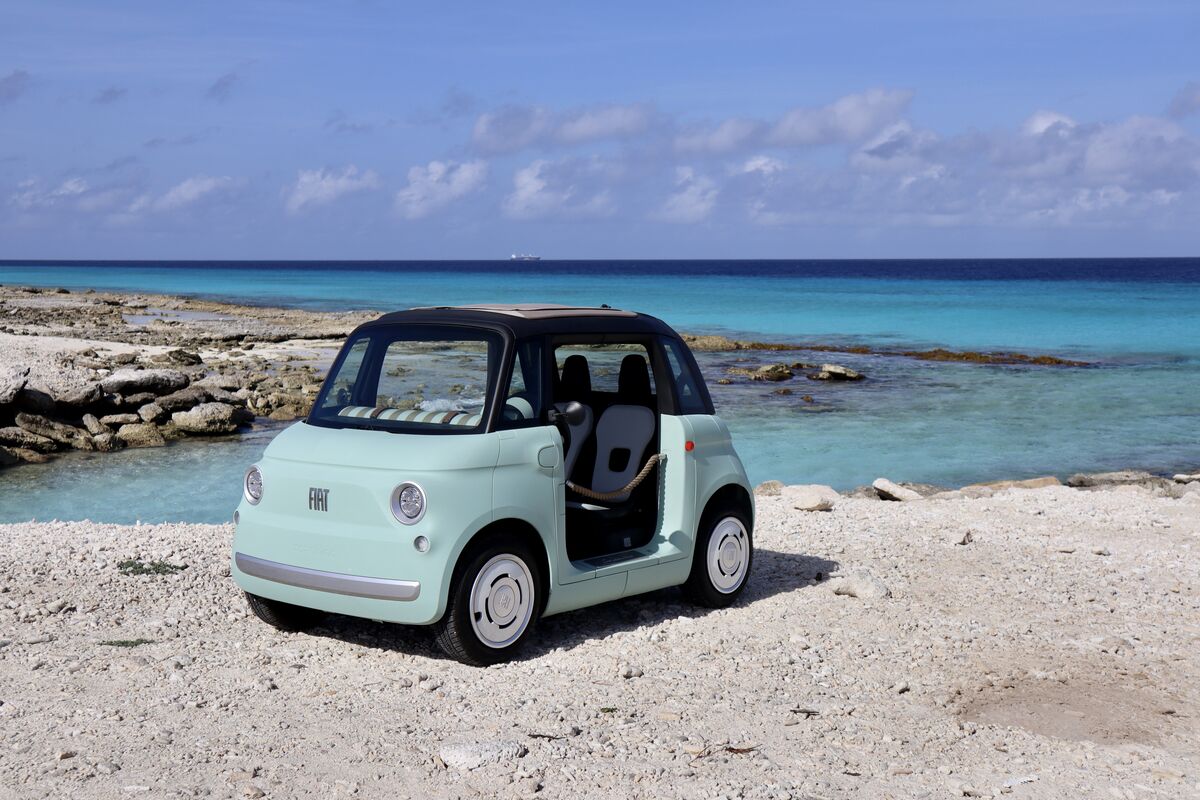 Mint-green Fiat Topolino EV on a Bonaire beach